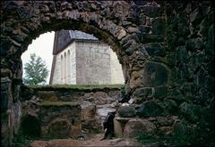Nydala Abbey monastery building surrounded by trees under a cloudy sky