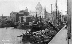 Vintage view of barges docked at Canning Dock in the Port of Liverpool, England, with the historic Port of Liverpool Building in the background, circa 1910