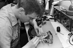 Technician splicing wires in Aircraft Intermediate Maintenance Department on USS John F. Kennedy aircraft carrier during Fleet Ex 1-90