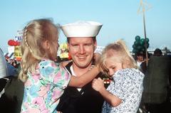 Machinist's Mate 1st Class Gary Church holding his two daughters after coming ashore from aircraft carrier USS John F. Kennedy at Naval Air Station Norfolk Virginia USA