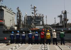 Sailors from USS Vicksburg in formation alongside USNS Guadalupe during replenishment at sea