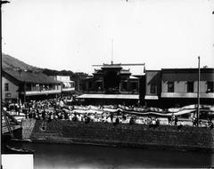 Chinese Dragon procession in Chinatown, Honolulu with traditional buildings and people along the river