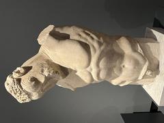 Ancient marble sculpture of a seated figure with detailed facial features at Palais Massimo