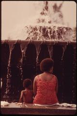 People cooling off beside a large outdoor fountain at Philadelphia Museum of Art on a sunny day