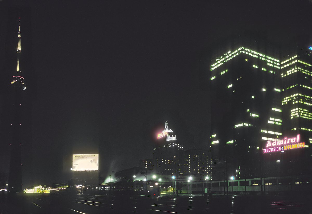 Night view of Toronto Union Station with illuminated CN Tower in the background