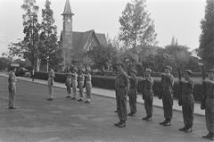 Black and white historic photograph of the guard changing ceremony at Oranje-Nassauboulevard and Burgemeester Bisschopsplein in Menteng, Batavia, July 1946, with Nassaukerk church in the background