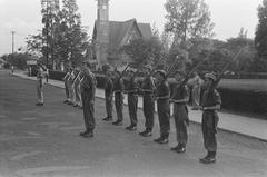 Black and white photo showing the changing of the guard ceremony at Burgemeester Bisschopsplein, Menteng, Batavia in July 1946 with Nassaukerk church visible in the background