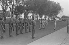 Black and white photograph of military troops performing a changing of the guard ceremony on Oranje-Nassauboulevard near Burgemeester Bisschopsplein in Menteng, Batavia, 1946