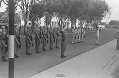 Black and white photograph of a changing of the guard ceremony at Oranje-Nassauboulevard and Burgemeester Bisschopsplein in Menteng, Batavia, July 1946
