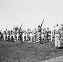 Massive reburial ceremony of war victims at Menteng Poeloeh cemetery in Batavia on April 5, 1948, with mourners gathered around graves