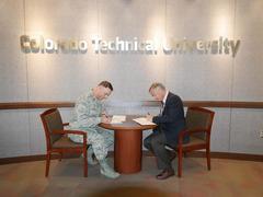 Lt. Col. Paul Contoveros and Mark Seglem signing education credit agreement at Colorado Technical University