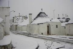 Snow-covered trulli houses in Alberobello, Italy