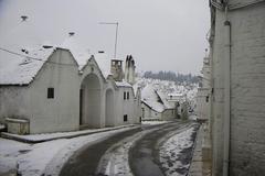 Snow-covered trulli houses in Alberobello, Italy during winter