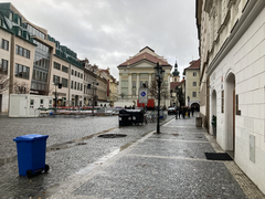 Cityscape of Prague with historic buildings and a church spire in soft evening light