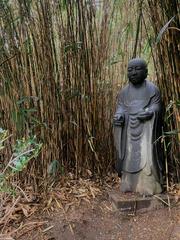 Statue of a Japanese monk at Shofuso Japanese House and Garden with visitors' offerings