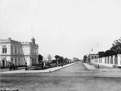 Historic black and white photo of Paseo Colón street in Lima around 1902 showing vintage architecture and horse-drawn carriages