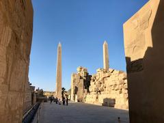 Karnak Temple central crossing in Luxor, Egypt with ancient columns and architectural details under blue sky