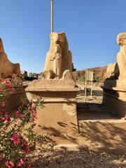 Karnak Temple in Luxor, Egypt with a long avenue of sphinx statues under blue sky