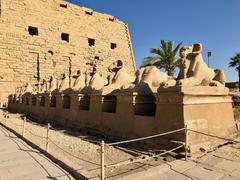 Allee des Sphinx at Karnak Temple in Luxor Egypt lined with sphinx statues and ancient temple structures under a clear blue sky