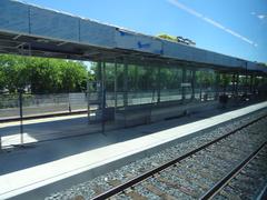 View from train window showing urban landscape with buildings and trees during daytime