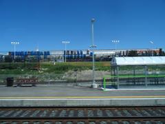 View from train window showing railway tracks and green landscape during daytime