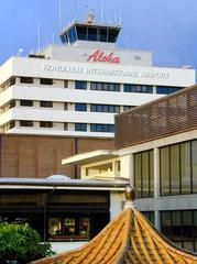 Honolulu Airport terminal building with airplanes and clear blue sky