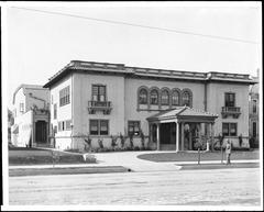 Exterior view of the Ebell Club, a two-story Spanish colonial building with symmetric facade, portico entrance, Spanish tiled roofs and arched windows on Figueroa Street, Los Angeles, ca. 1900-1909