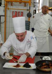 Four Indonesian chefs participating in a cooking demonstration with American and Filipino chefs during the USDA Council of Chefs program