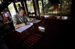 Chief of Naval Operations Adm Mike Mullen signing guest book at Vietnamese President Ho Chi Minh's cottage in Hanoi Vietnam June 2007