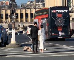 Young married couple getting photographed at Pont d'Iéna in Paris