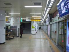 Hongik University Station entrance and street view with people and buses in Seoul