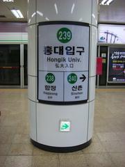 Hongik University Station entrance with modern architecture and people walking