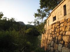 Seoul city wall in August 2007 with people walking along the historic stone structure