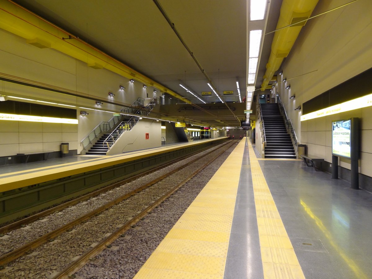 View of the platform at Hospitales metro station with signage and rail tracks