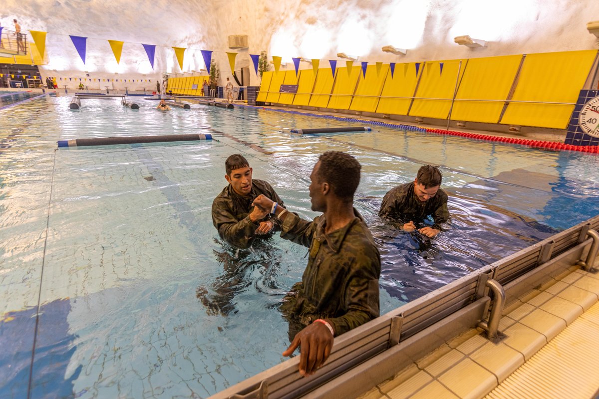 Army Reserve Capt. Steven Tirado and Sgt. Asuerus Thompson fist bump after swim obstacle course at Interallied Confederation of Reserve Officers Military Competition 2023 in Finland