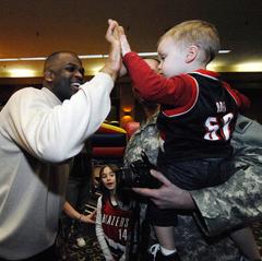 Portland Trail Blazers head coach Nate McMillan high-fiving young fan Jackson Creswell at Make It Better Holiday Carnival
