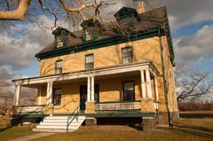 Historic yellow brick house of Fort Hancock against a cloudy sky