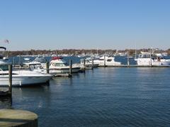 Boats docked at Great Kills Park Marina on calm water under a clear sky