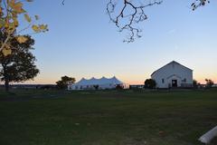 Chapel with white event tent set up outdoors surrounded by pine trees