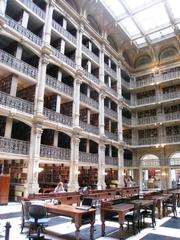Interior view of George Peabody Library with towering shelves filled with books and ornate architecture in Baltimore