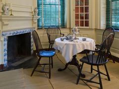 Round table set for tea with four Windsor chairs in historic Germantown White House interior