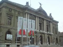 Grand Théâtre de Genève illuminated in the evening with people gathered outside