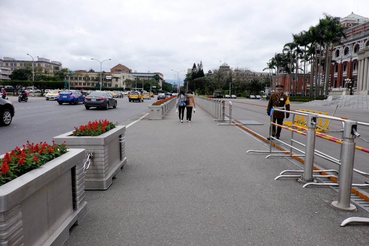 Concrete barriers and metal fences in front of a presidential building plaza for enhanced security
