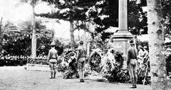 Queen Liliuokalani's Boy Scout troop standing guard at the Royal Mausoleum surrounded by floral tributes