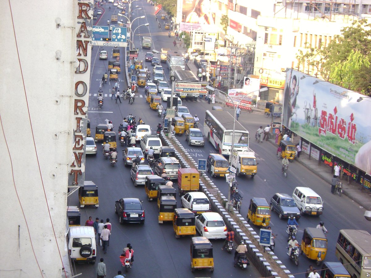 Anna Salai street near old Anand theater signal in Chennai with vehicles and buildings