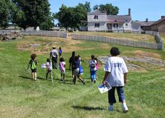 Children and camp staff following Ranger Jimmy during a summer camp tour at Hampton National Historic Site