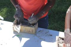 Close up of hands molding clay into a brick mold at Hampton National Historic Site