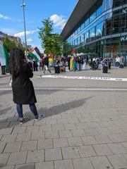 Pro Palestina demonstration at Muenster Hauptbahnhof with protesters holding flags and banners