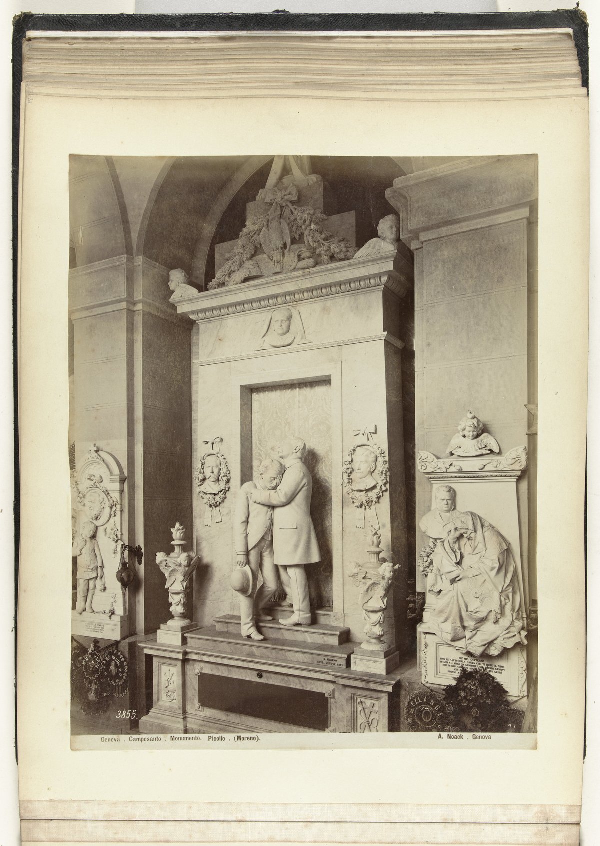 Marble grave monument featuring a sculpture of a man comforting another man in Genova Camposanto cemetery