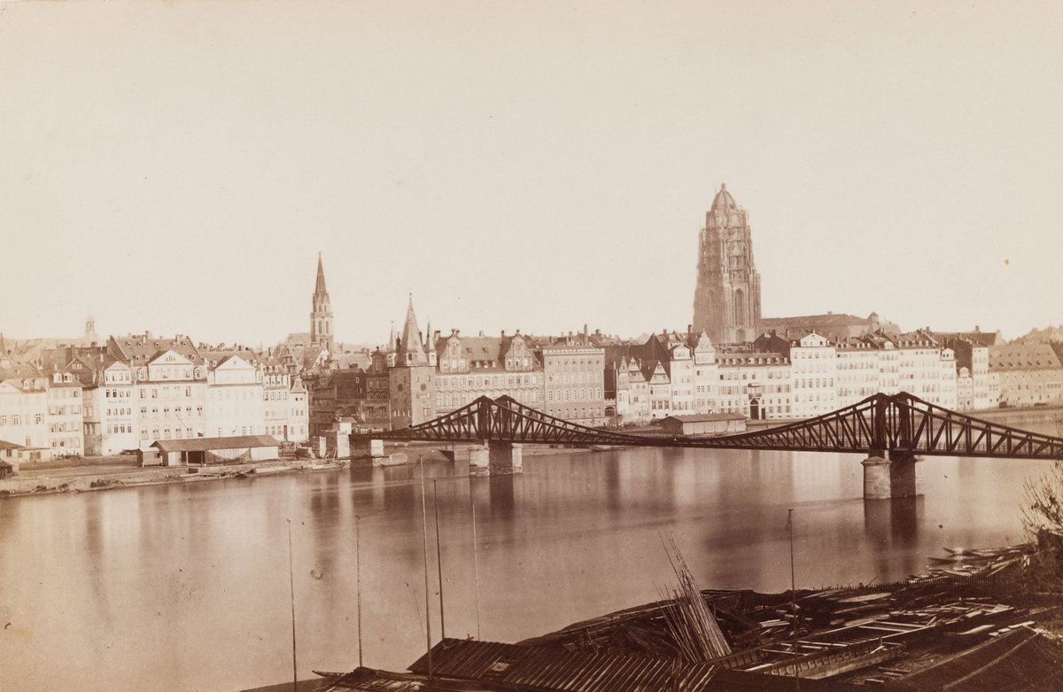 View across the Main River in Frankfurt featuring the Iron Footbridge and cathedral, historic black and white albumen print from 1868-1871 by Carl Friedrich Mylius